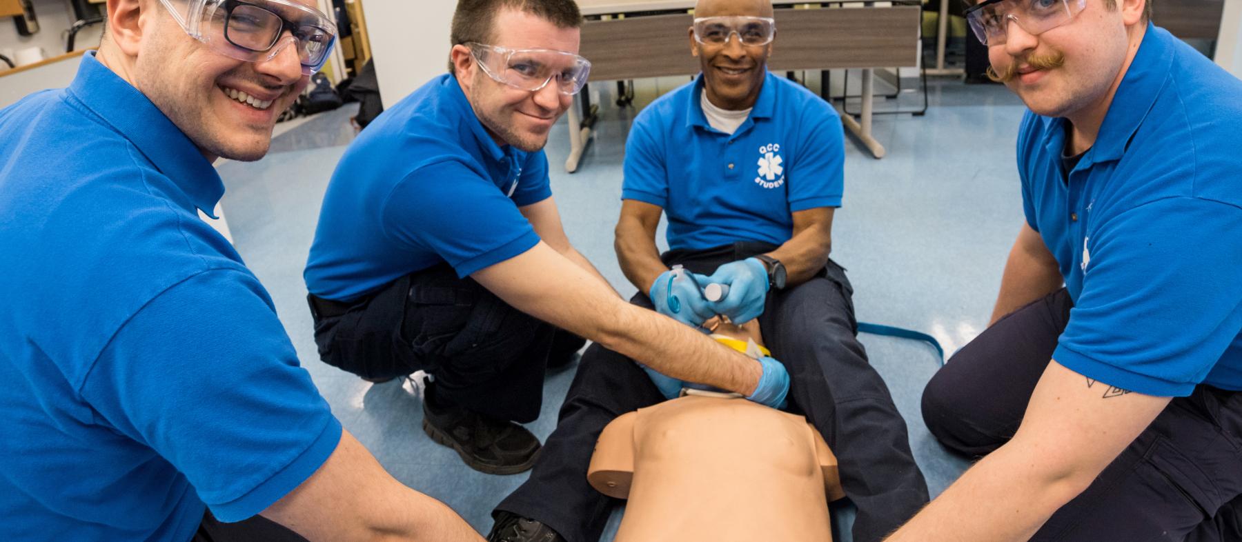 A class of paramedics practice on a dummy