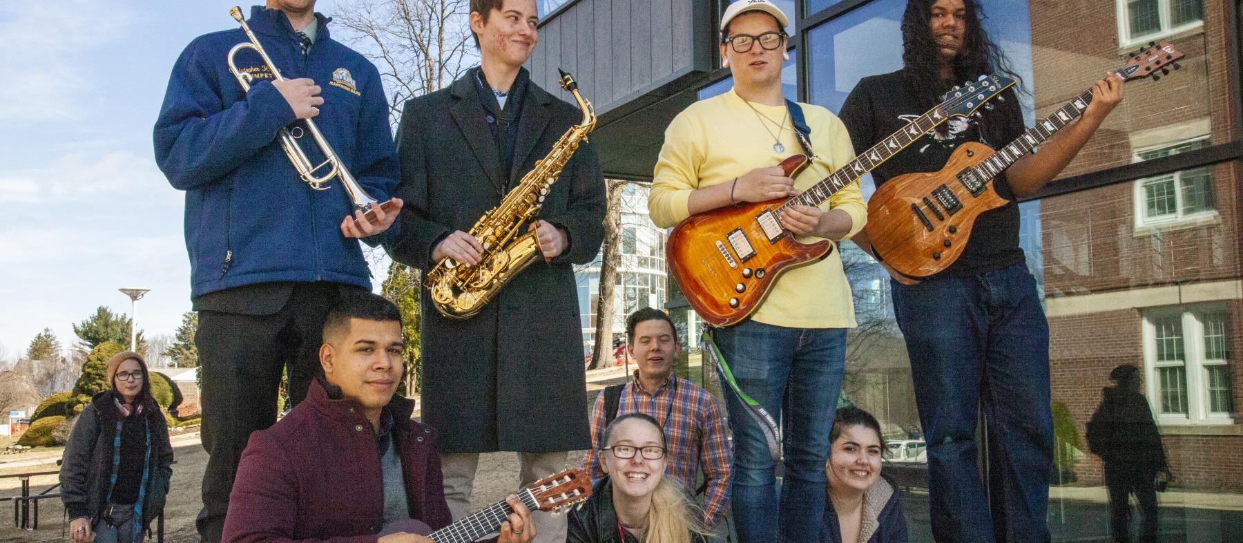 Music students pose with their instruments in from the QuEST building