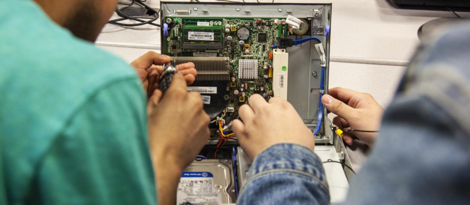 Students work on internal computer components in a lab