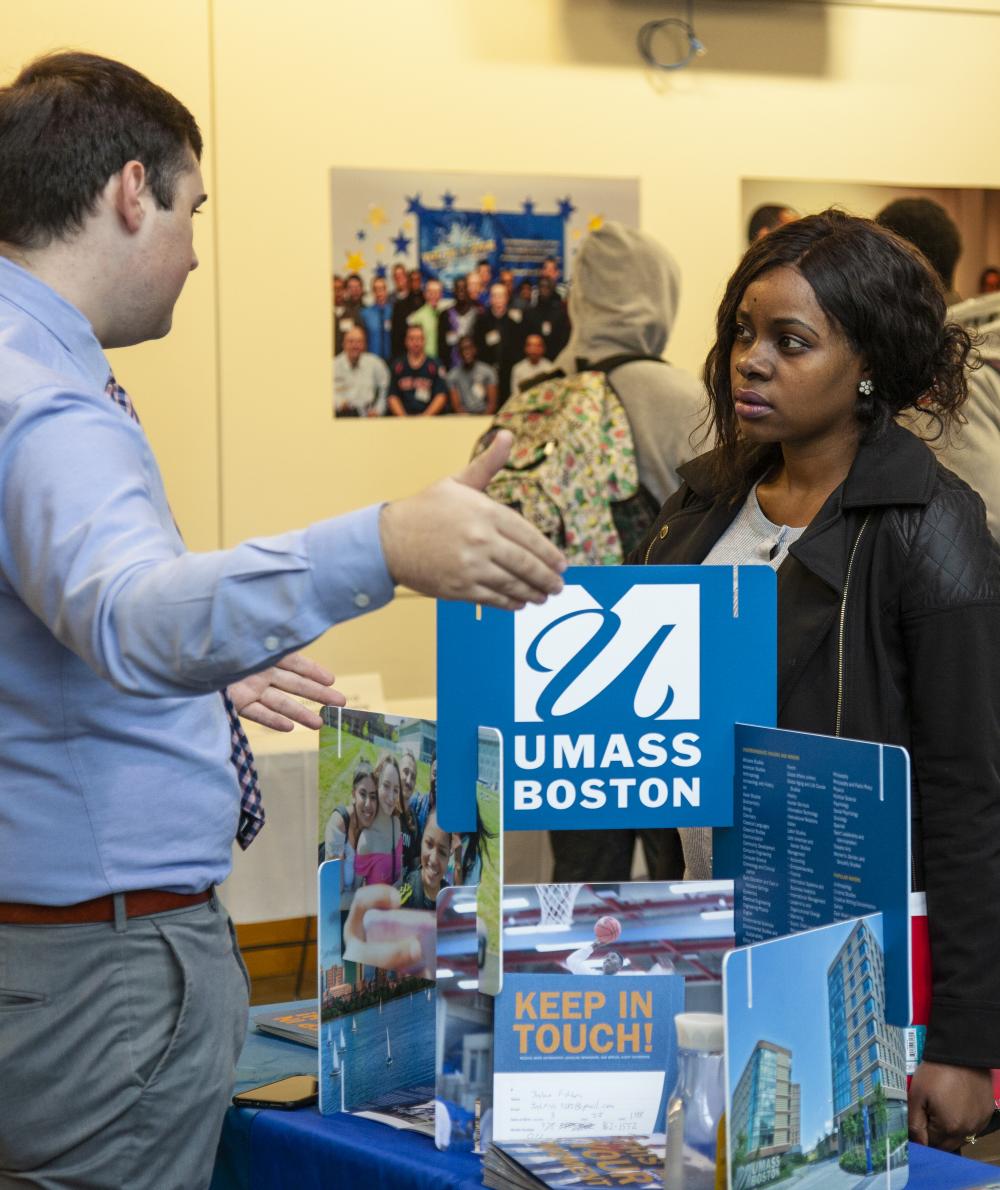 A recruiter talks to a student at a transfer fair
