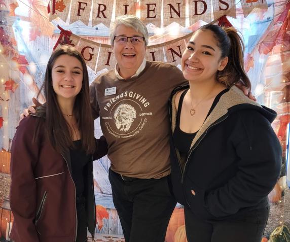 Terry Vecchio, Dean of Students, poses with two students during QCC’s fall Friendsgiving in the QCC cafeteria