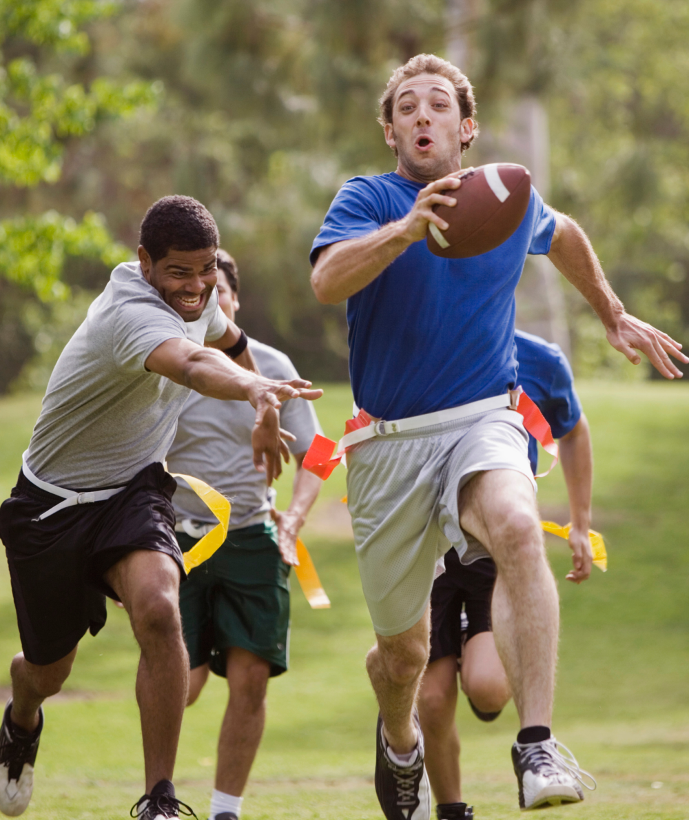 A group of students play flag football in a field