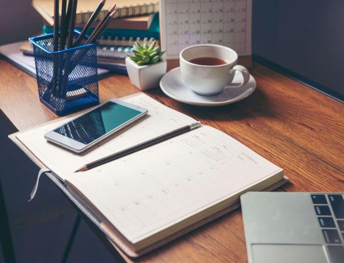 A wooden desk full of books and calendars