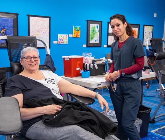 Assistant Director of Operations for External Affairs Shirley Dempsey (left) donating blood.