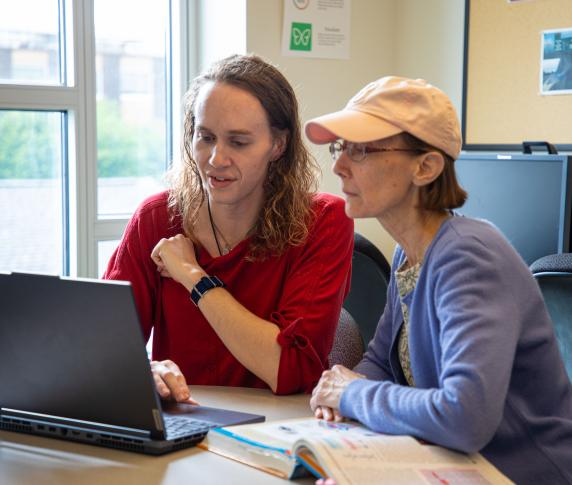 Two tutors at table in a tutoring session.