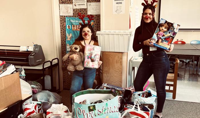 From left: Southbridge Elementary School liaisons Karina Alvarado and Selena Robles with donations from QCC's Human Services Clu