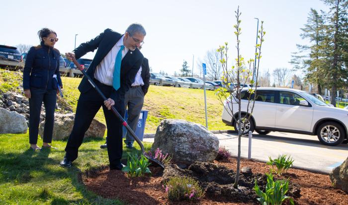 QCC President Dr. Luis Pedraja helps to plant a new tree for Earth Day.